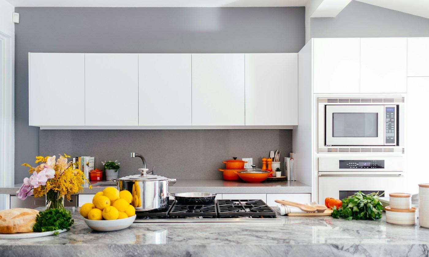 A white kitchen with a marble island