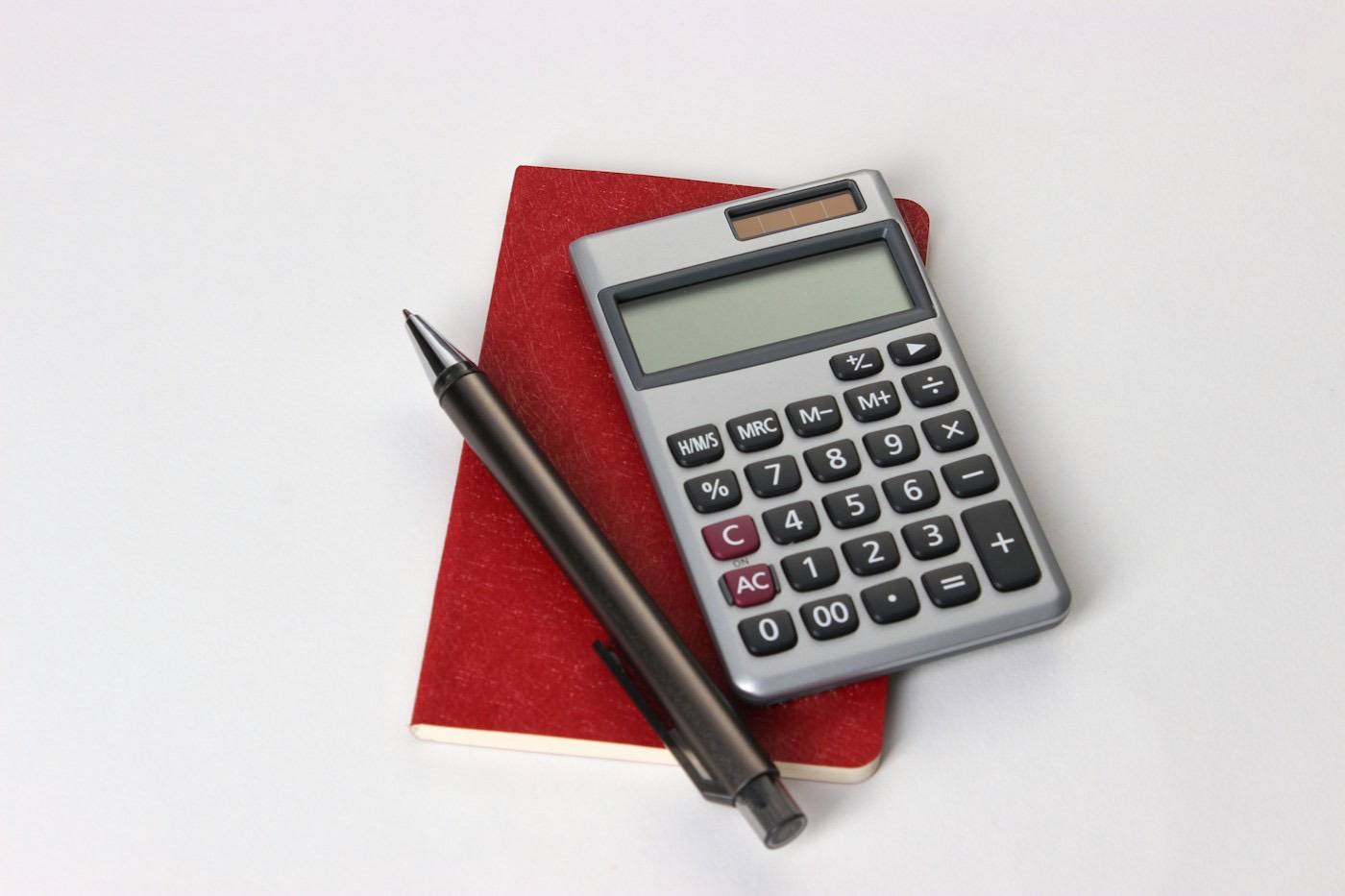 A calculator beside a pen