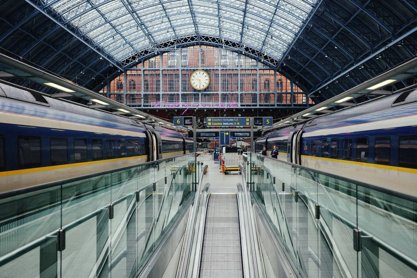 A train at a station platform beside a clock